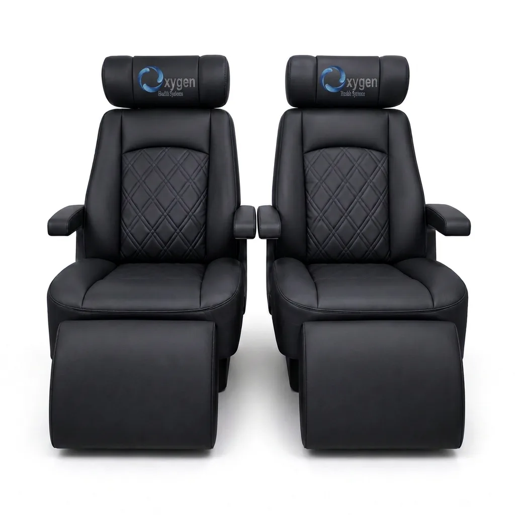 Pair of black quilted-leather reclining captain's chairs with embroidered Oxygen Health Systems headrests, padded armrests, and extended footrests