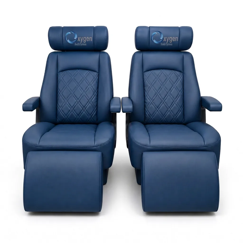 Pair of navy blue quilted-leather reclining captain's chairs with embroidered Oxygen Health Systems headrests, padded armrests, and extended footrests